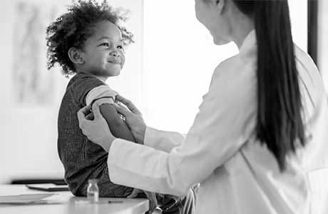 a doctor placing a Band-Aid on a little boy