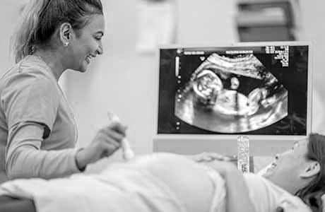 an ultrasound technician giving an ultrasound to a pregnant woman 