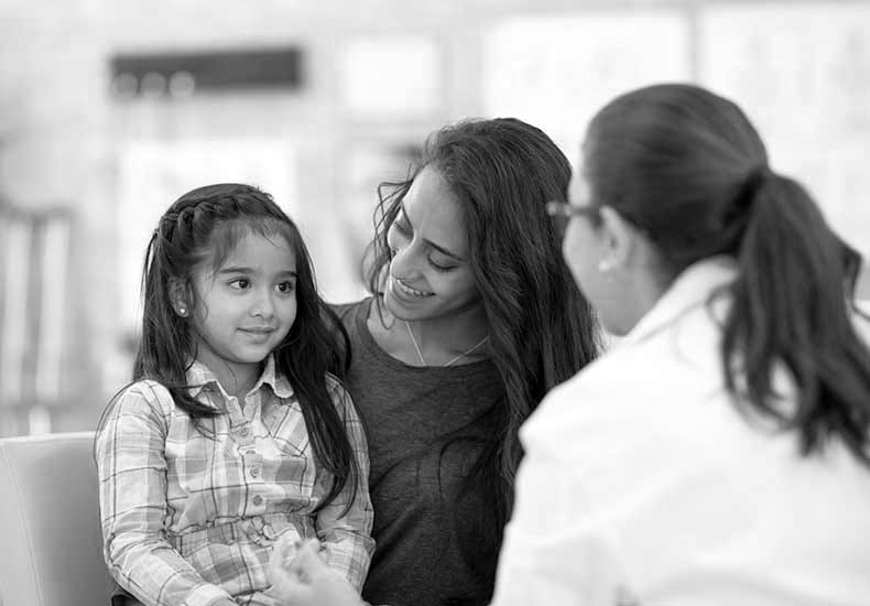 a young mother and daughter talking to a doctor